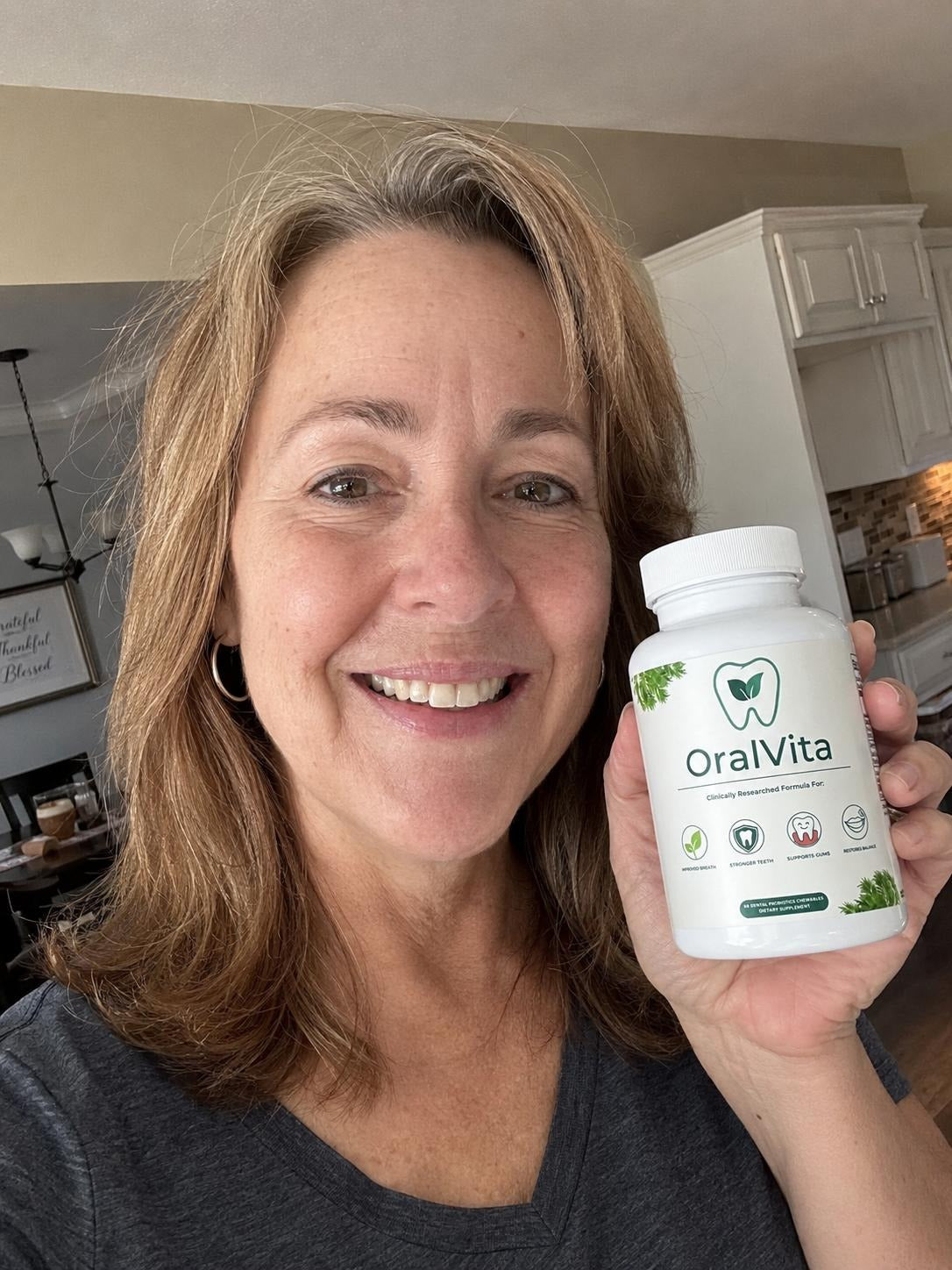 OralVita lifestyle image showing an adult holding the product at home